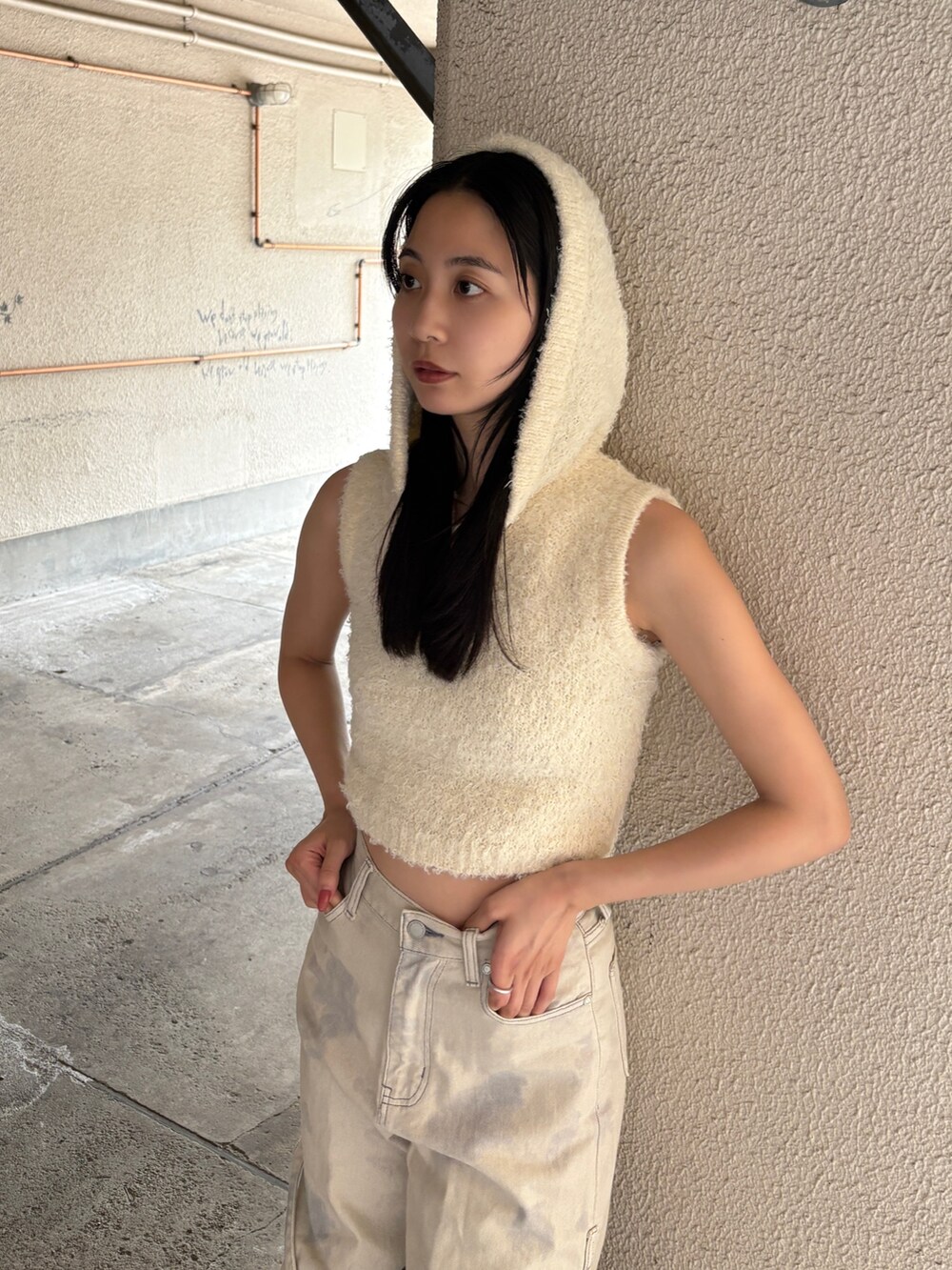 ホワイト系のデニムパンツ、ホワイト系のニット/セーター、シルバー系のスニーカーを着用したレディースの春コーディネートの2枚目の写真