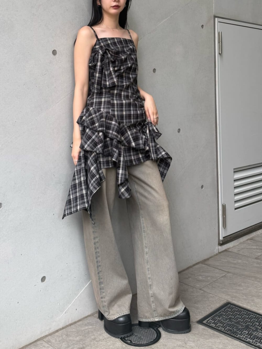 ブラウン系のデニムパンツ、ブラック系のワンピース、ブラック系のローファーを着用したレディースの夏コーディネートの2枚目の写真