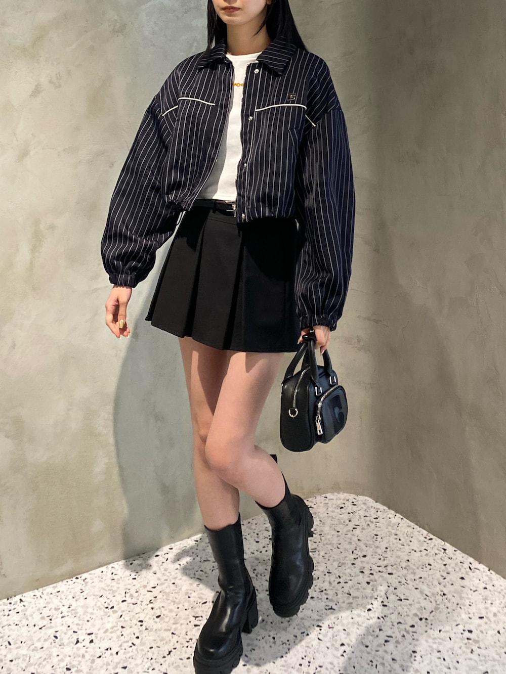 ブラック系のスカート、その他のブルゾン、ホワイト系のTシャツ/カットソーを着用したレディースの冬コーディネートの2枚目の写真