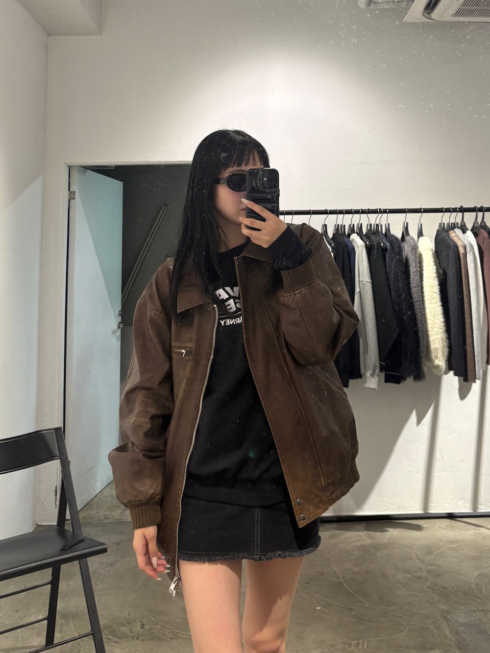 ブラック系のスカート、ブラック系のスウェット、ブラウン系のブルゾンを着用したレディースの秋コーディネートの2枚目の写真