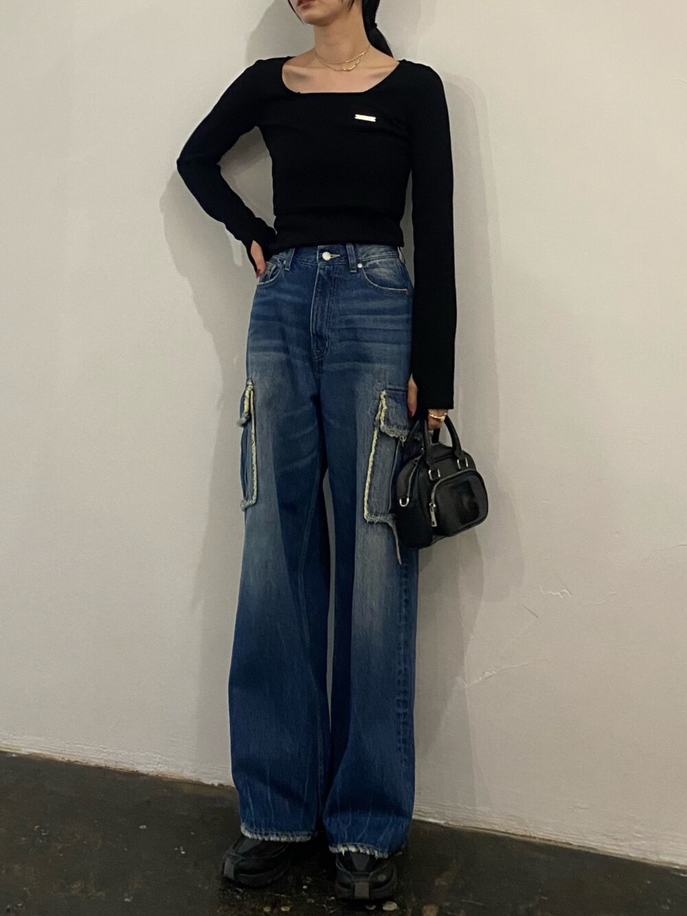 ブルー系のデニムパンツ、ブラック系のTシャツ/カットソーを着用したレディースの春コーディネートの2枚目の写真