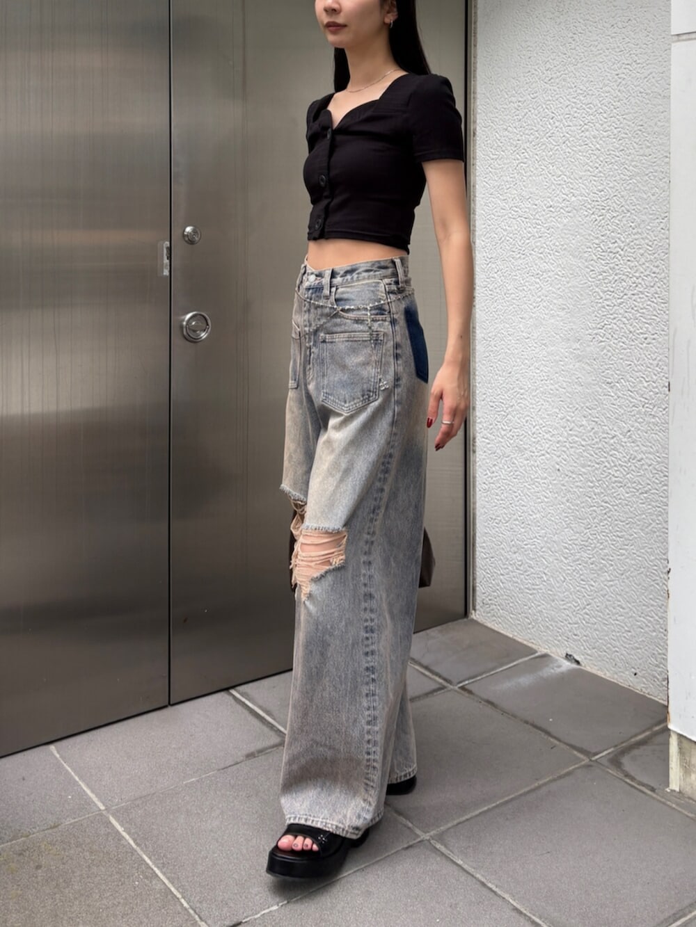 ブラック系のサンダル、ブルー系のデニムパンツ、ブラウン系のショルダーバッグを着用したレディースの夏コーディネートの4枚目の写真