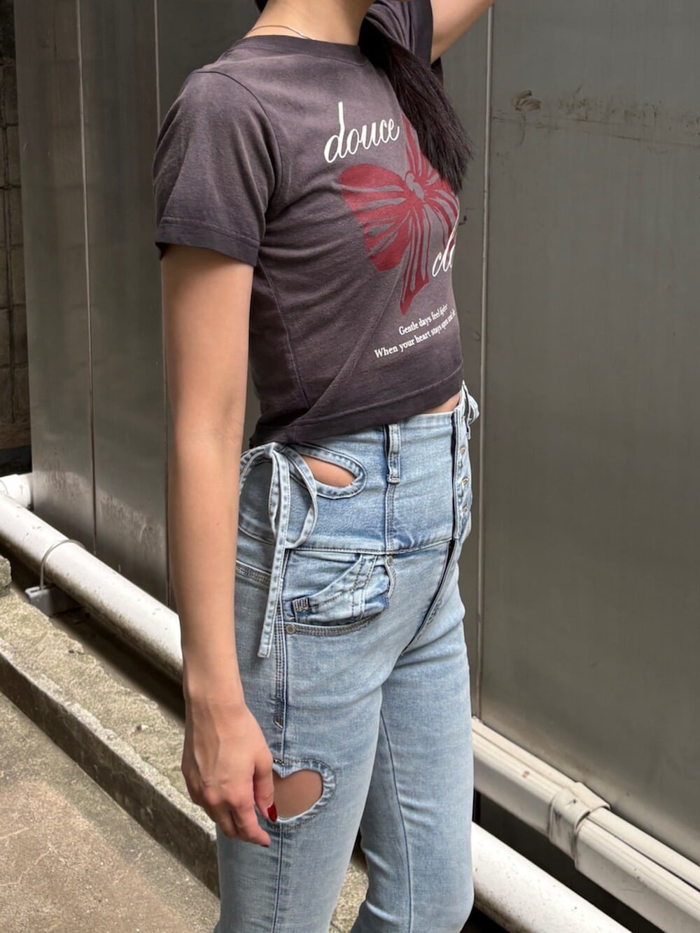 ブラック系のサンダル、ブラック系のTシャツ/カットソー、ブルー系のデニムパンツを着用したレディースの夏コーディネートの6枚目の写真