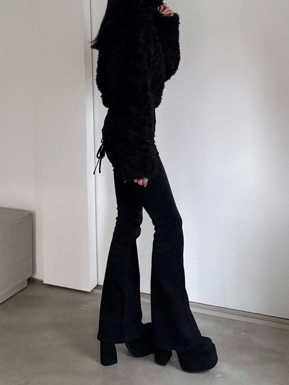 ブラック系のデニムパンツ、ブラック系のブルゾン、ブラック系のブーツを着用したレディースの秋コーディネートの2枚目の写真