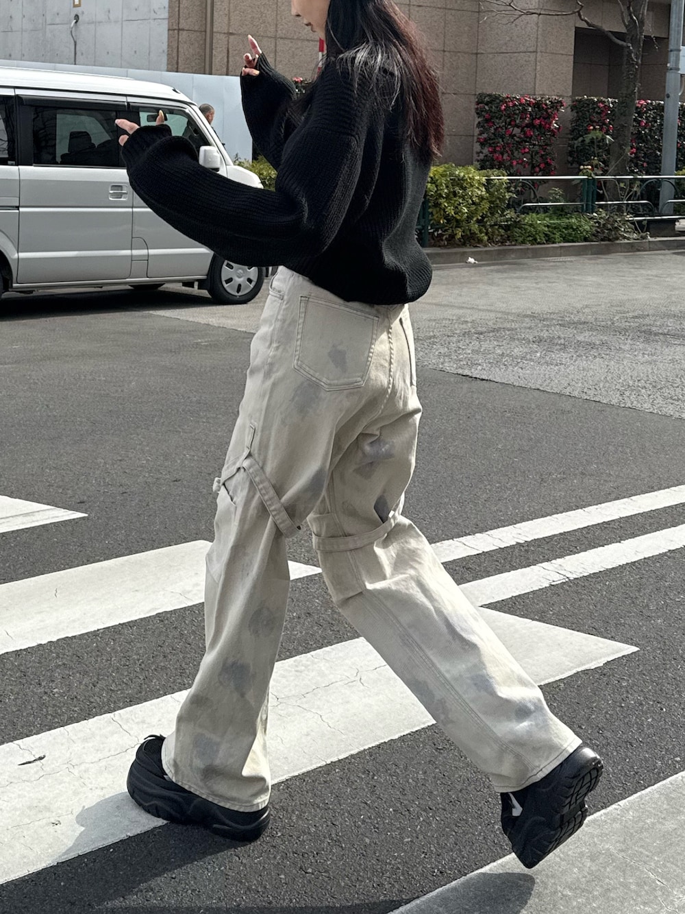 ホワイト系のデニムパンツ、ブラック系のニット/セーター、ブラック系のスニーカーを着用したレディースの冬コーディネートの2枚目の写真