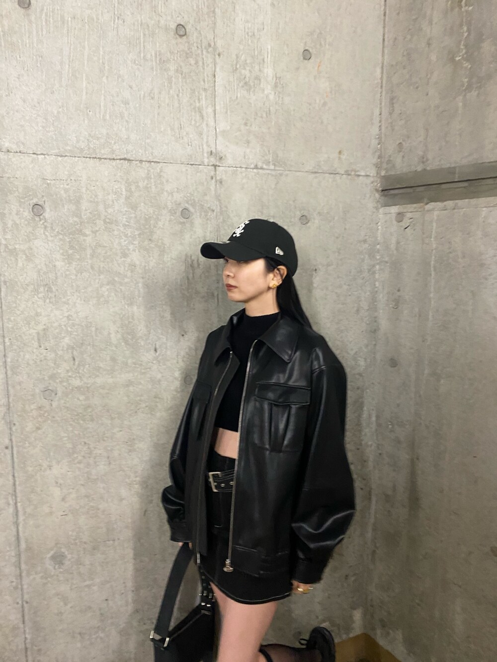 ブラック系のスカート、ブラック系のブルゾン、ブラック系のニット/セーターを着用したレディースの冬コーディネートの3枚目の写真