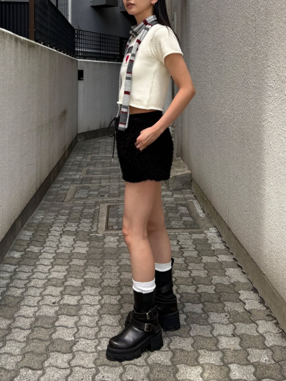 ブラック系のその他パンツ、ブラック系のブーツ、ホワイト系のニット/セーターを着用したレディースの夏コーディネートの2枚目の写真