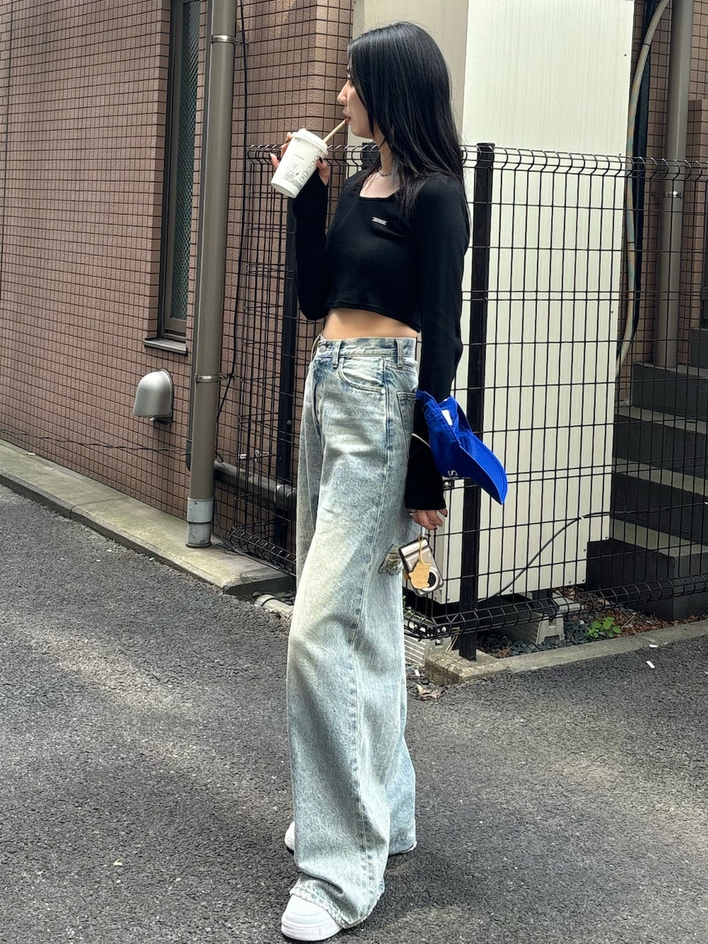 ブルー系のデニムパンツ、ブラック系のTシャツ/カットソーを着用したレディースの秋コーディネートの2枚目の写真