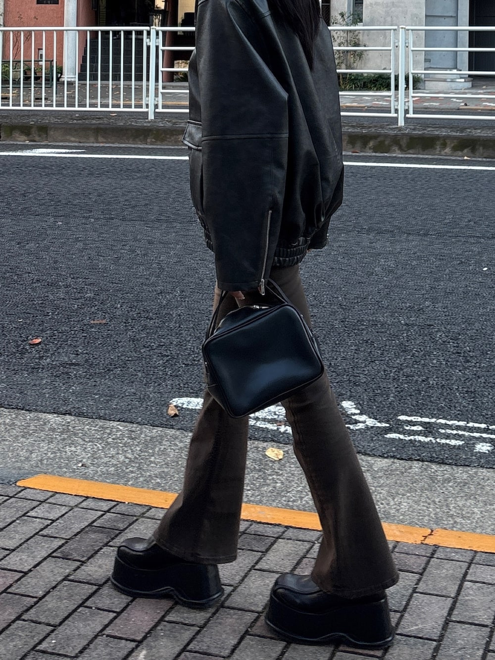 ブラウン系のデニムパンツ、ブラック系のブルゾン、ブラック系のローファーを着用したレディースの冬コーディネートの3枚目の写真