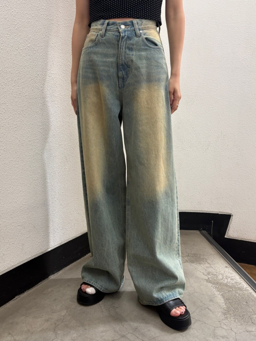 ブルー系のデニムパンツ、ブラック系のハンドバッグ、ブラック系のサンダルを着用したレディースの夏コーディネートの9枚目の写真