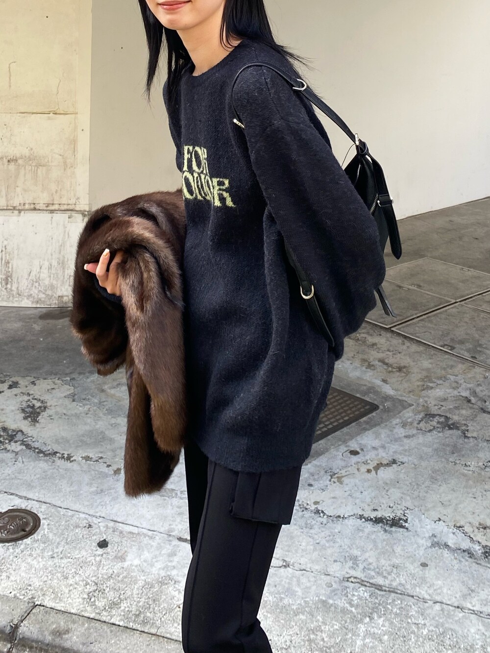 ブラック系のニット/セーター、ブラック系のブーツ、ブラック系のカーゴパンツを着用したレディースの冬コーディネートの3枚目の写真