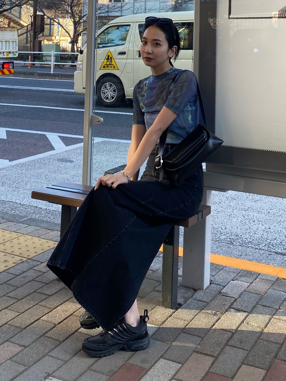 ブラック系のスカート、ブルー系のTシャツ/カットソーを着用したレディースの春コーディネートの2枚目の写真