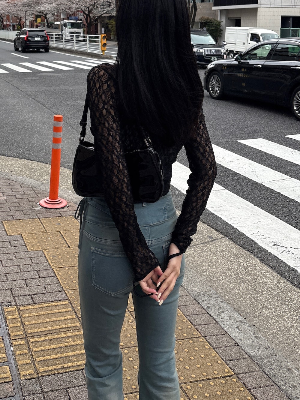 ブルー系のデニムパンツ、ブラック系のTシャツ/カットソー、ブラック系のパンプスを着用したレディースの春コーディネートの2枚目の写真