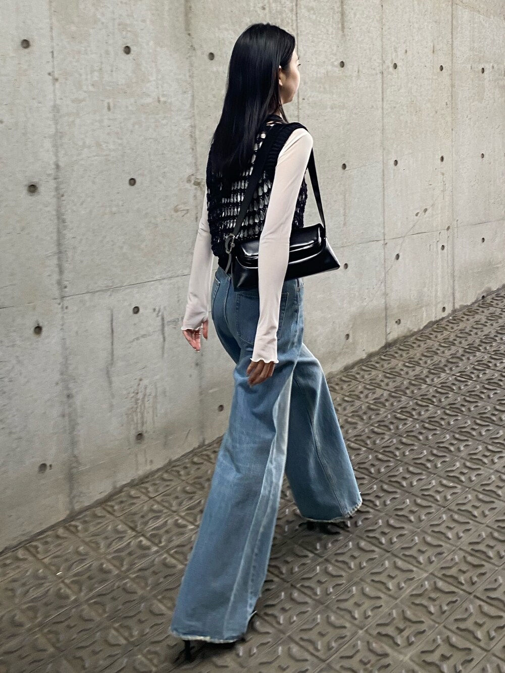 ブルー系のデニムパンツ、ブラック系のタンクトップ、ホワイト系のTシャツ/カットソーを着用したレディースの春コーディネートの2枚目の写真