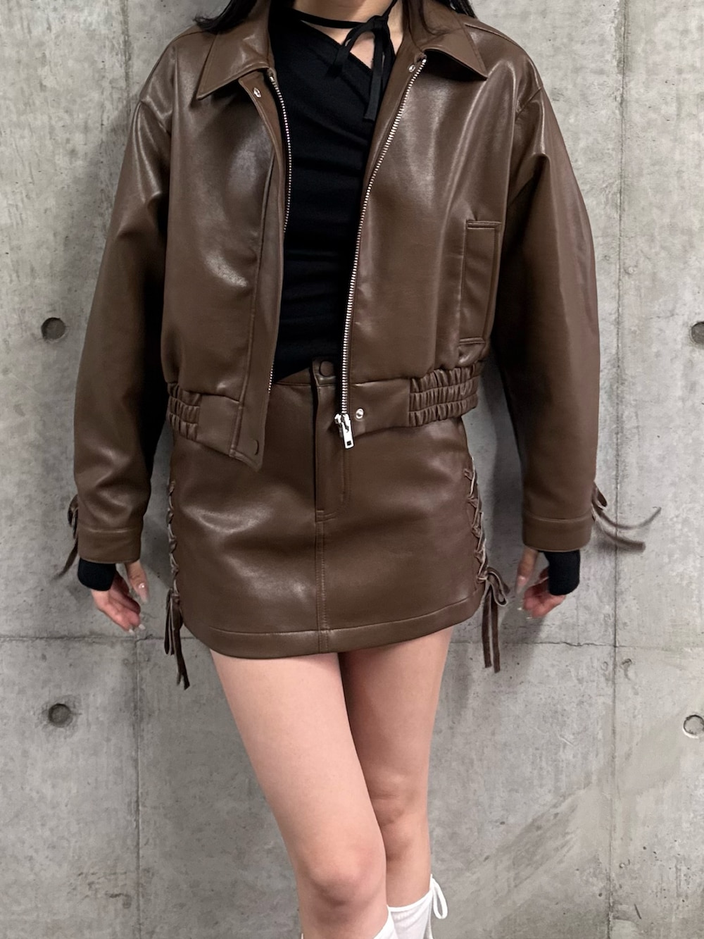 ブラウン系のブルゾン、ブラウン系のスカート、ブラック系のスニーカーを着用したレディースの冬コーディネートの3枚目の写真