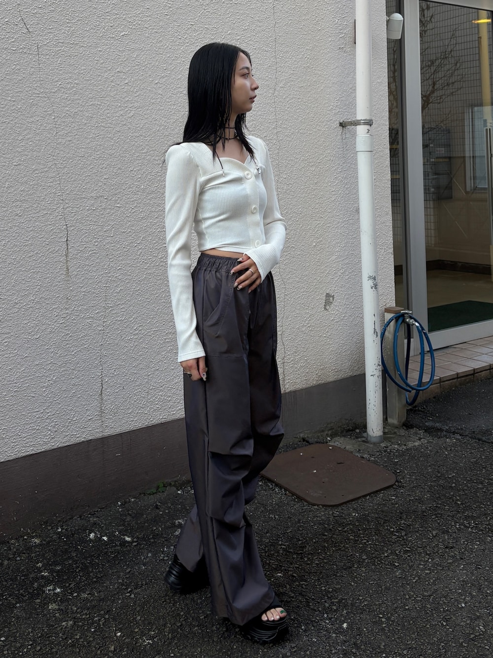 ホワイト系のTシャツ/カットソー、ブラウン系のその他パンツ、ブラック系のサンダルを着用したレディースの春コーディネートの2枚目の写真