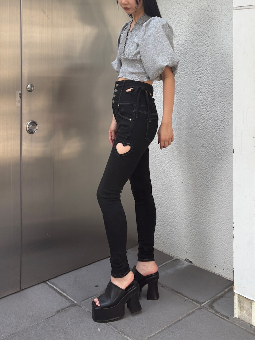 ブラック系のデニムパンツ、グレー系のTシャツ/カットソー、ブラック系のサンダルを着用したレディースの夏コーディネートの2枚目の写真