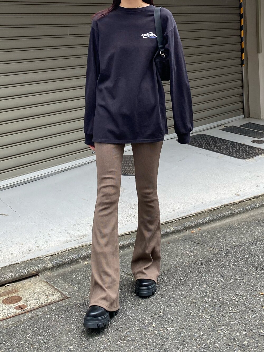 ブラウン系のその他パンツ、ブラック系のTシャツ/カットソー、ブラック系のハンドバッグを着用したレディースの秋コーディネートの2枚目の写真