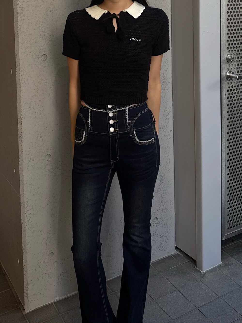 ブルー系のデニムパンツ、ブラック系のニット/セーター、ホワイト系のサンダルを着用したレディースの春コーディネートの3枚目の写真