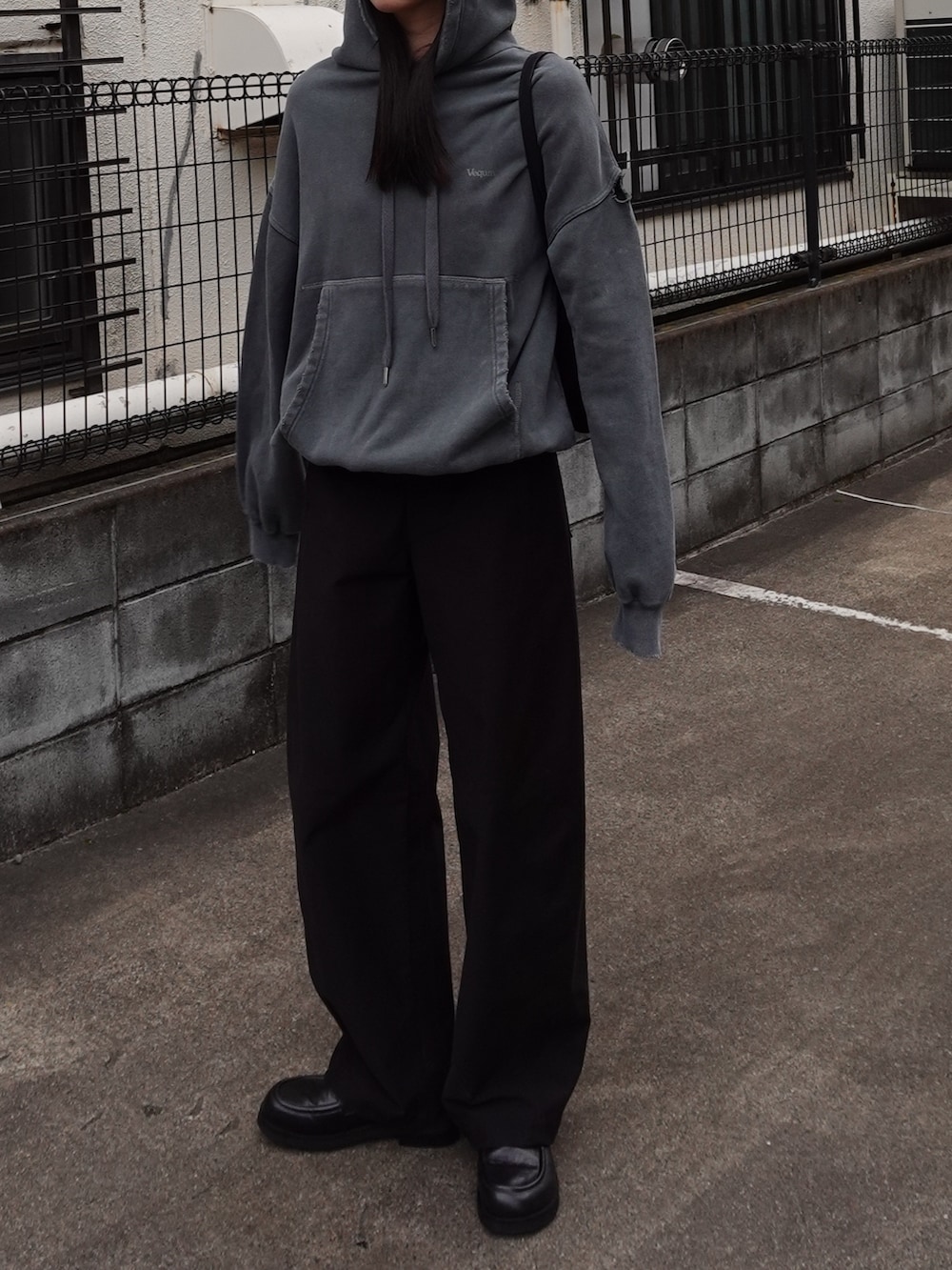 グリーン系のパーカー、ブラック系のローファーを着用したレディースの秋コーディネートの2枚目の写真