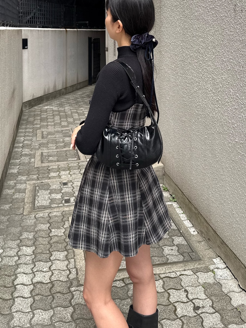 ブラック系のワンピース、ブラック系のブーツを着用したレディースの冬コーディネートの2枚目の写真