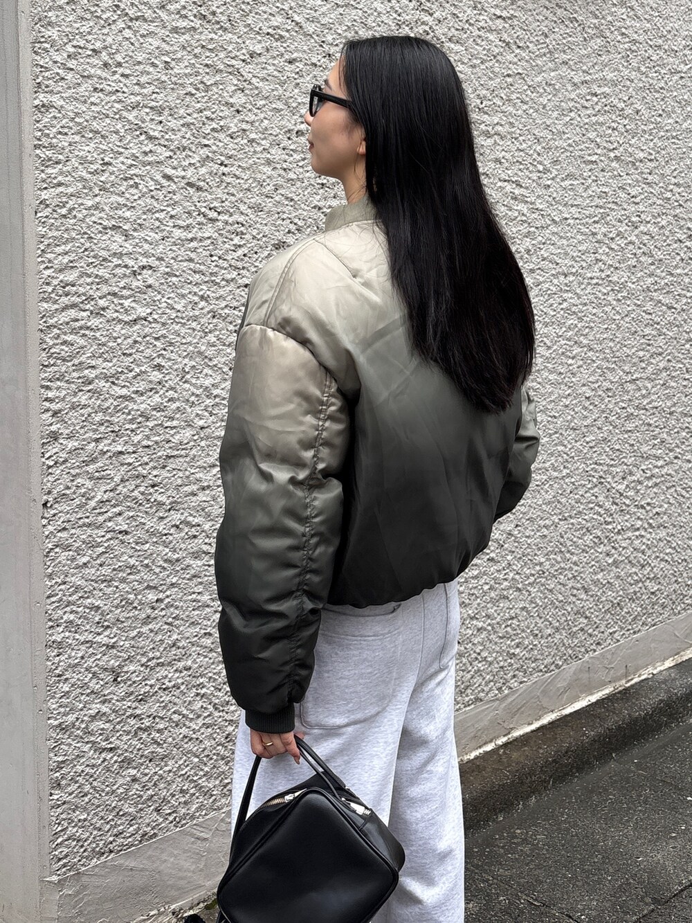 グレー系のスウェットパンツ、グリーン系のブルゾンを着用したレディースの冬コーディネートの3枚目の写真