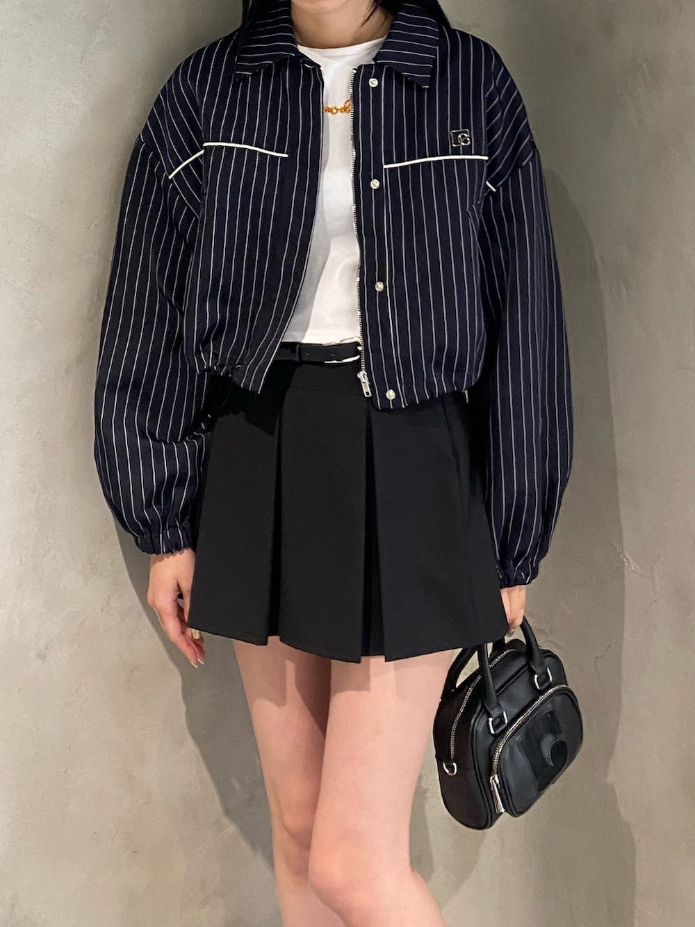 ブラック系のスカート、その他のブルゾン、ホワイト系のTシャツ/カットソーを着用したレディースの冬コーディネートの3枚目の写真