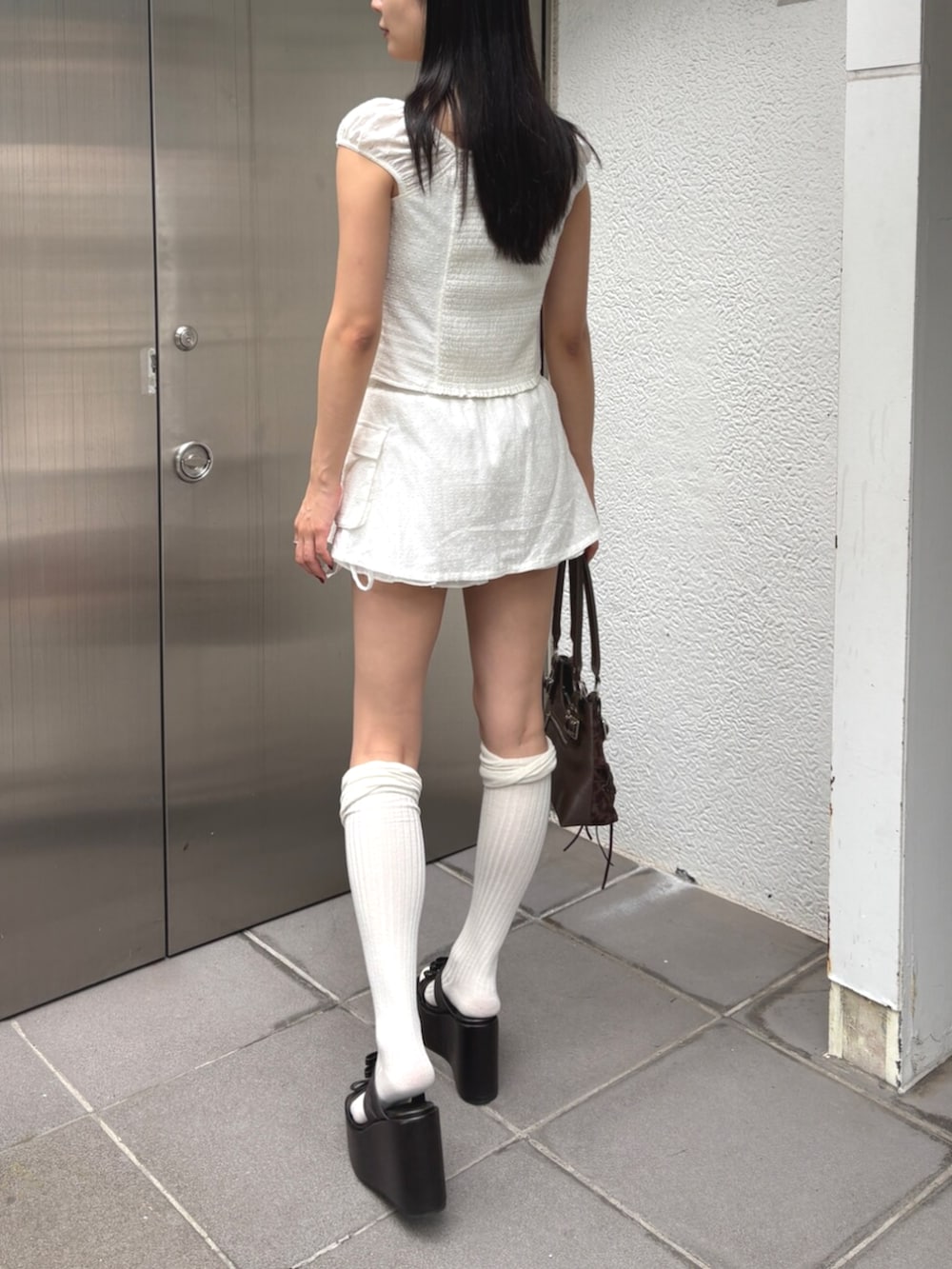 ブラック系のサンダル、ホワイト系のシャツ/ブラウス、ホワイト系のスカートを着用したレディースの夏コーディネートの3枚目の写真