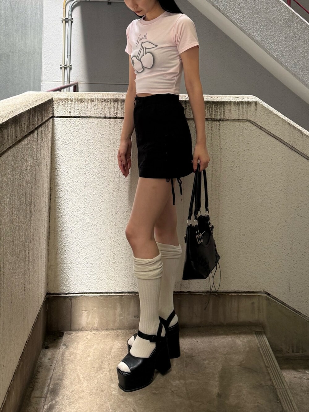 ブラック系のサンダル、ブラック系のショルダーバッグ、ピンク系のTシャツ/カットソーを着用したレディースの夏コーディネートの3枚目の写真