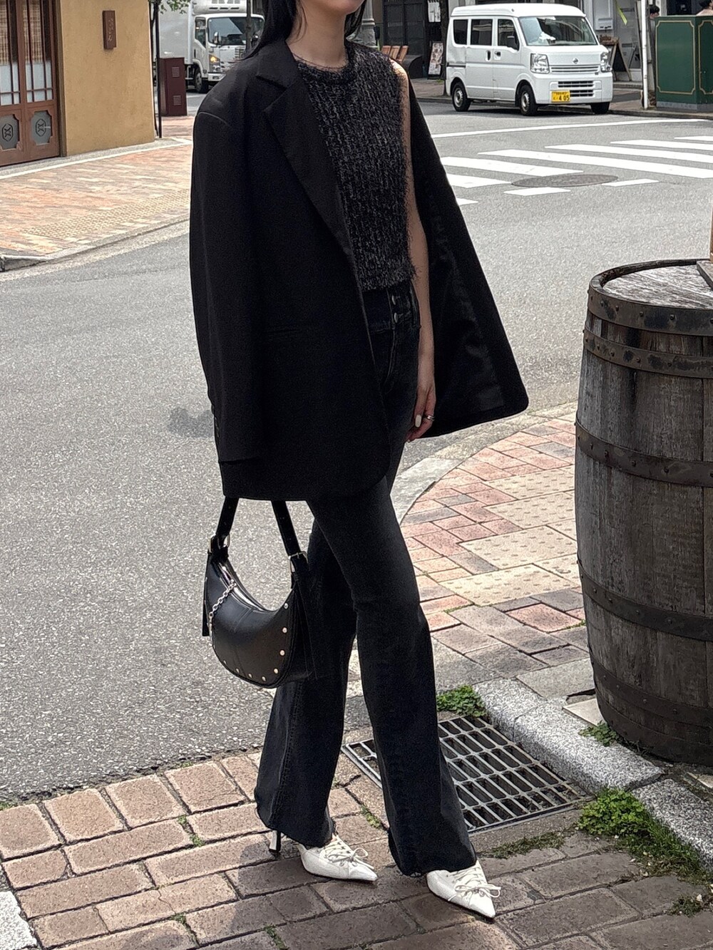 ブラック系のデニムパンツ、ブラック系のニット/セーター、ホワイト系のパンプスを着用したレディースの春コーディネートの3枚目の写真