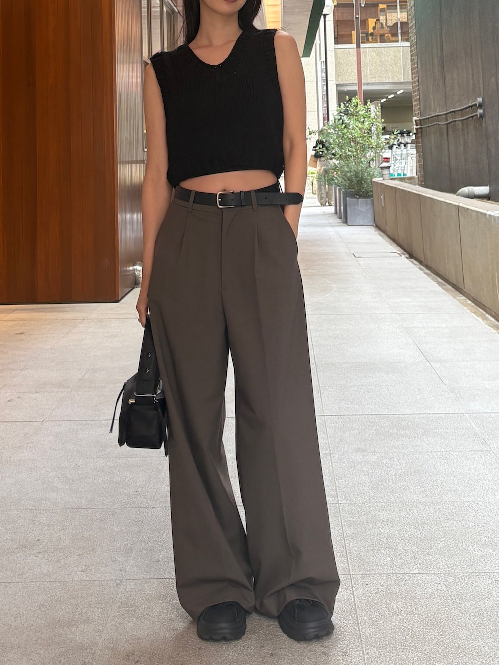 ブラウン系のニット/セーター、ブラック系のハンドバッグ、ブラウン系のその他パンツを着用したレディースの春コーディネートの2枚目の写真