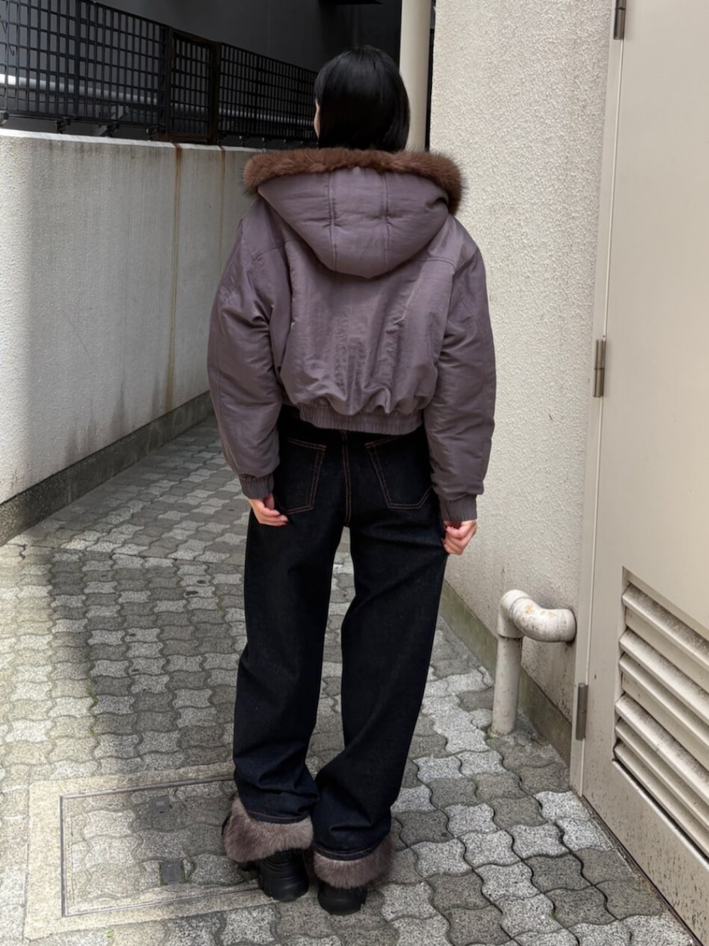 ブルー系のデニムパンツ、グレー系のブルゾン、ブラック系のブーツを着用したレディースの秋コーディネートの3枚目の写真