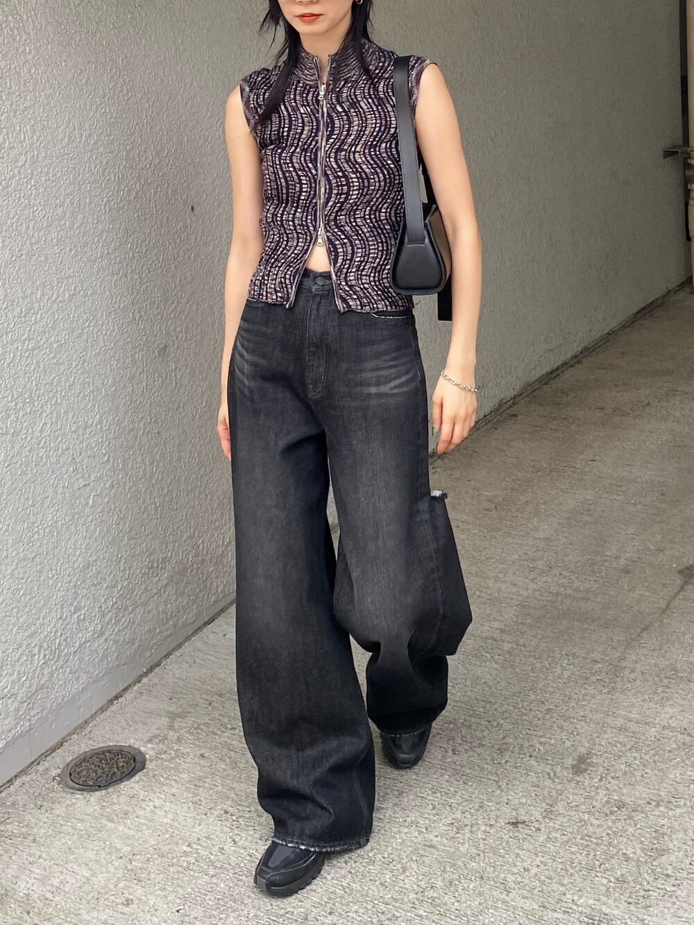 ブラック系のデニムパンツ、ブラウン系のタンクトップを着用したレディースの夏コーディネートの3枚目の写真