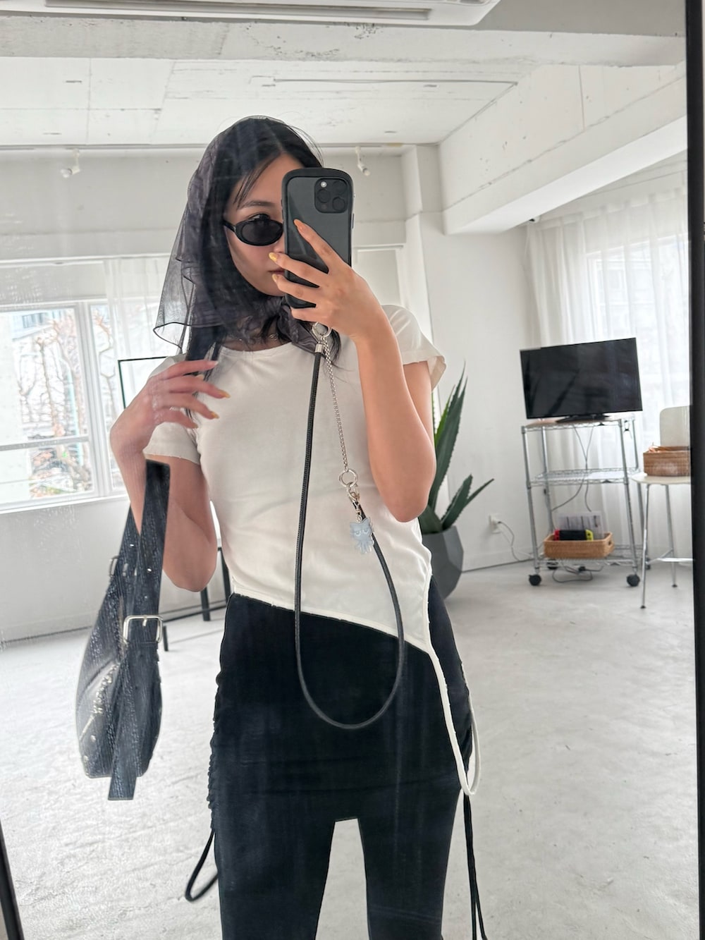 ブラック系のその他パンツ、ホワイト系のTシャツ/カットソー、ブラック系のハンドバッグを着用したレディースの春コーディネートの3枚目の写真