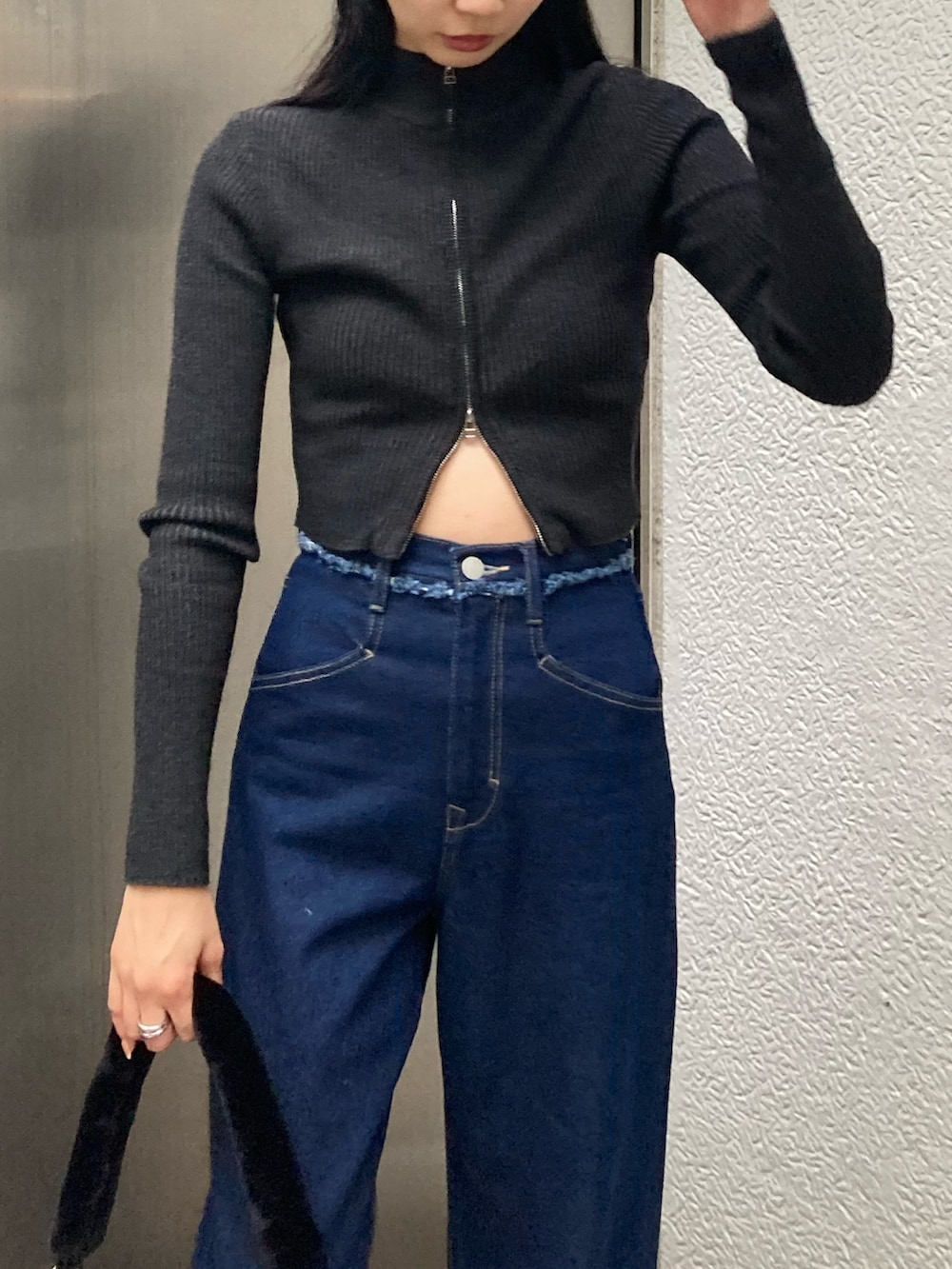 ブルー系のデニムパンツ、ブラック系のニット/セーターを着用したレディースの秋コーディネートの2枚目の写真