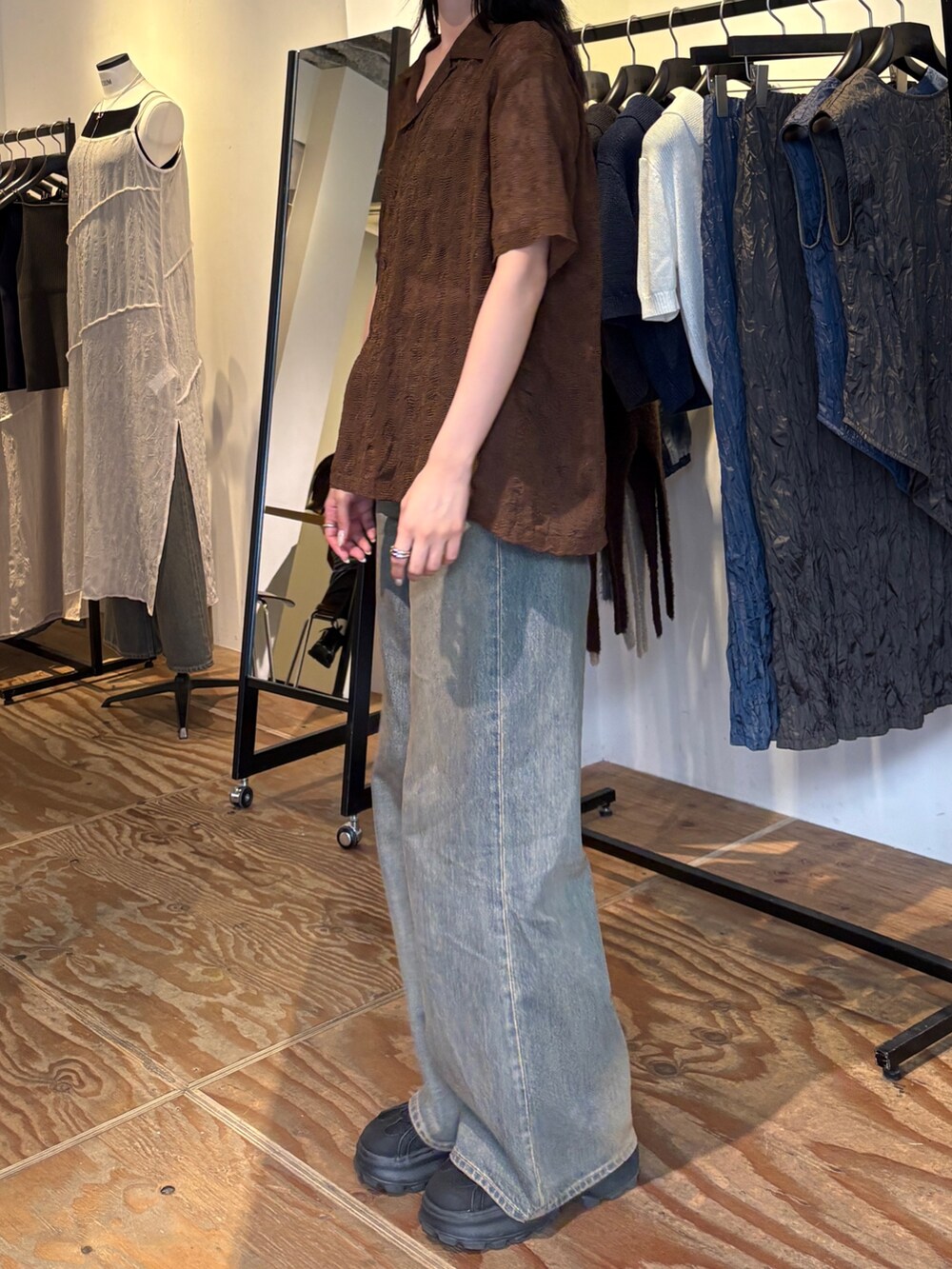 ブルー系のデニムパンツ、ブラウン系のシャツ/ブラウス、ブラック系のサンダルを着用したレディースの春コーディネートの2枚目の写真
