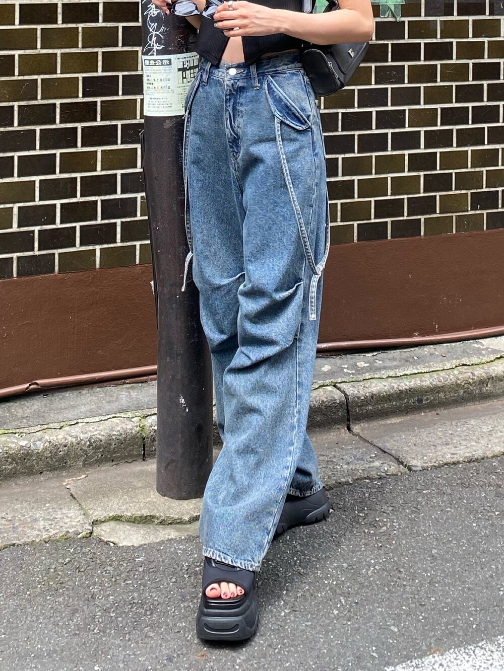 ブルー系のデニムパンツ、ブラック系のタンクトップ、ブラック系のサンダルを着用したレディースの夏コーディネートの2枚目の写真