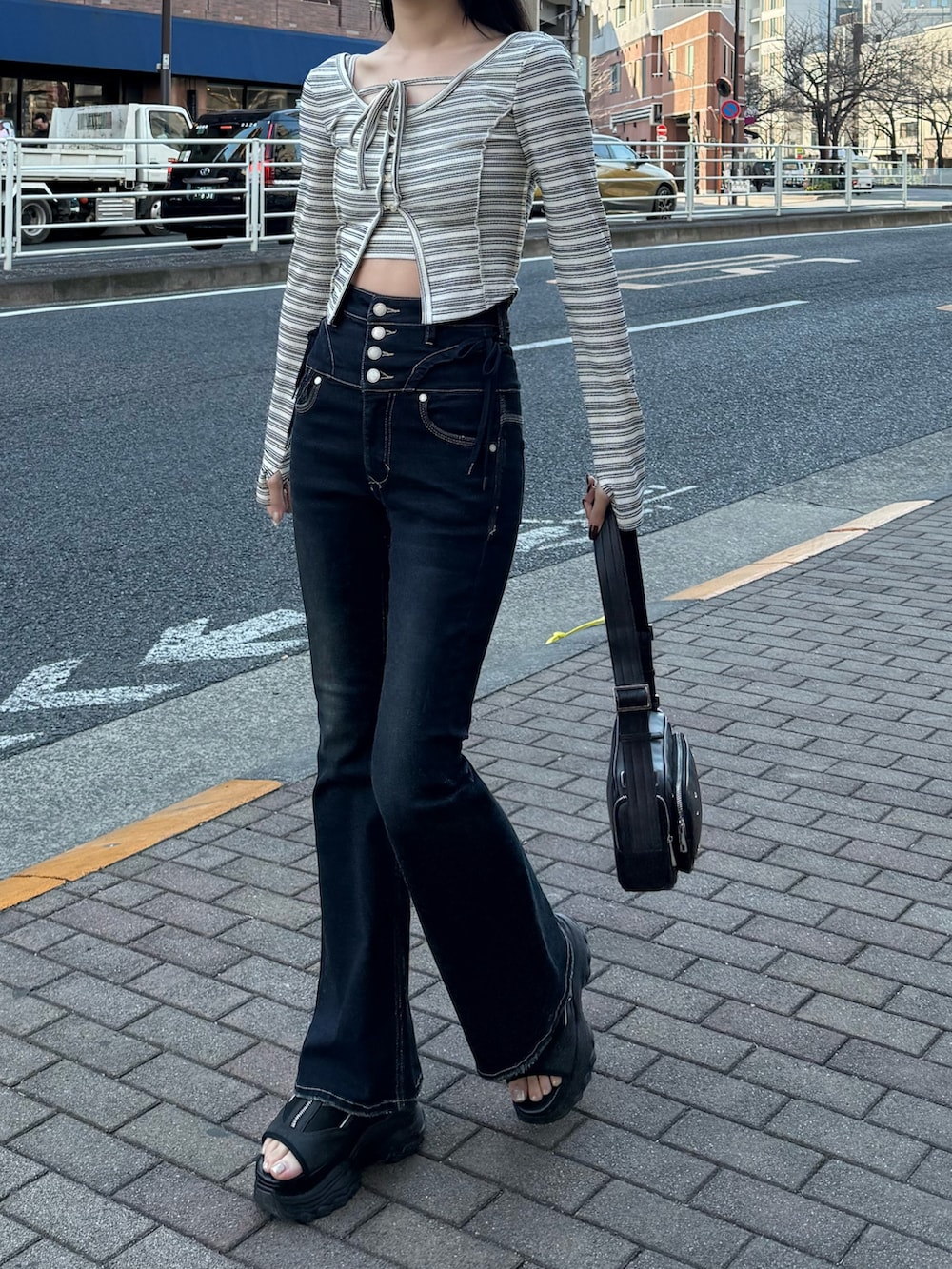 ブルー系のデニムパンツ、その他のTシャツ/カットソー、ブラック系のショルダーバッグを着用したレディースの春コーディネートの2枚目の写真