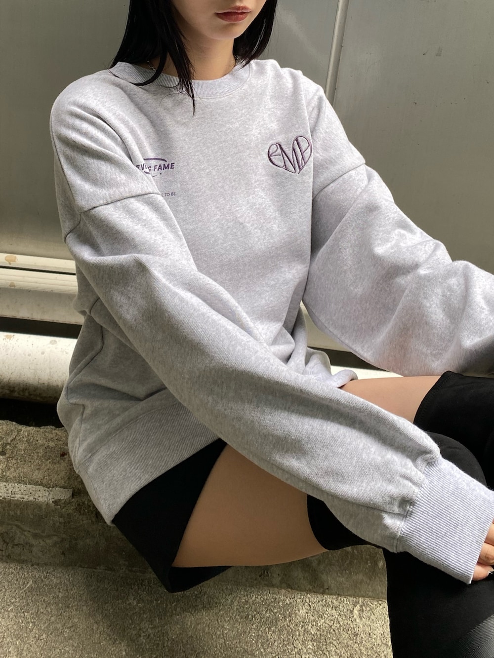 ブラック系のハンドバッグ、ブラック系のブーツ、グレー系のスウェットを着用したレディースの夏コーディネートの4枚目の写真