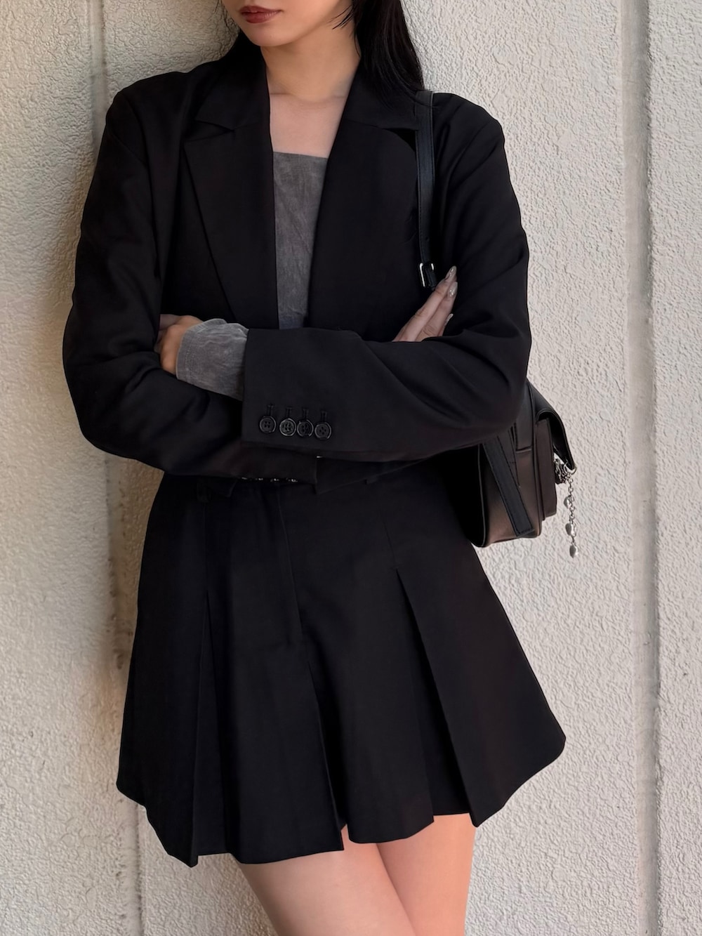 ブラック系のテーラードジャケット、ブラック系のスカート、ブラック系のローファーを着用したレディースの秋コーディネートの3枚目の写真