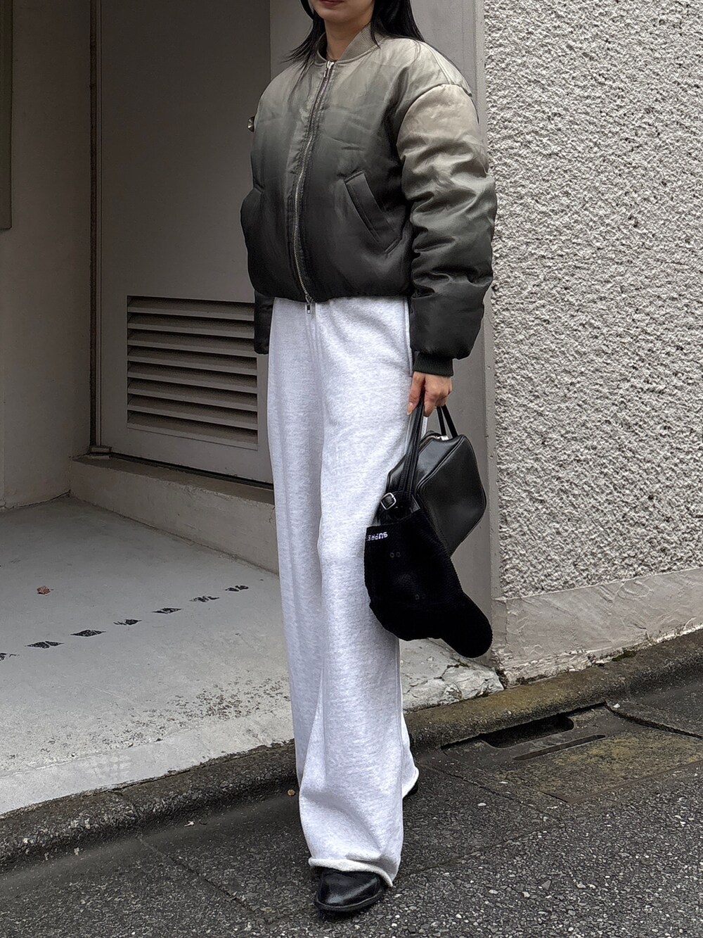 グレー系のスウェットパンツ、グリーン系のブルゾンを着用したレディースの冬コーディネートの2枚目の写真