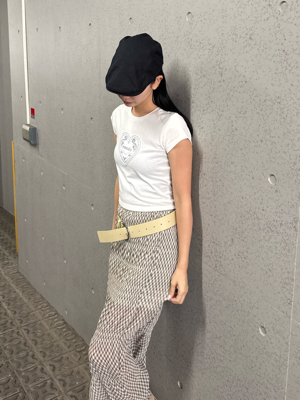 ホワイト系のTシャツ/カットソー、ベージュ系のスカート、ホワイト系のブーツを着用したレディースの春コーディネートの2枚目の写真