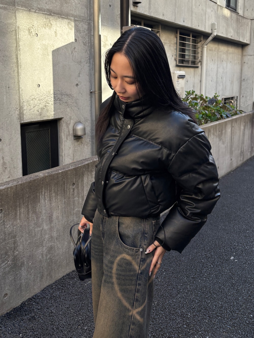 ブルー系のデニムパンツ、ブラック系のダウンジャケット/コートを着用したレディースの冬コーディネートの3枚目の写真