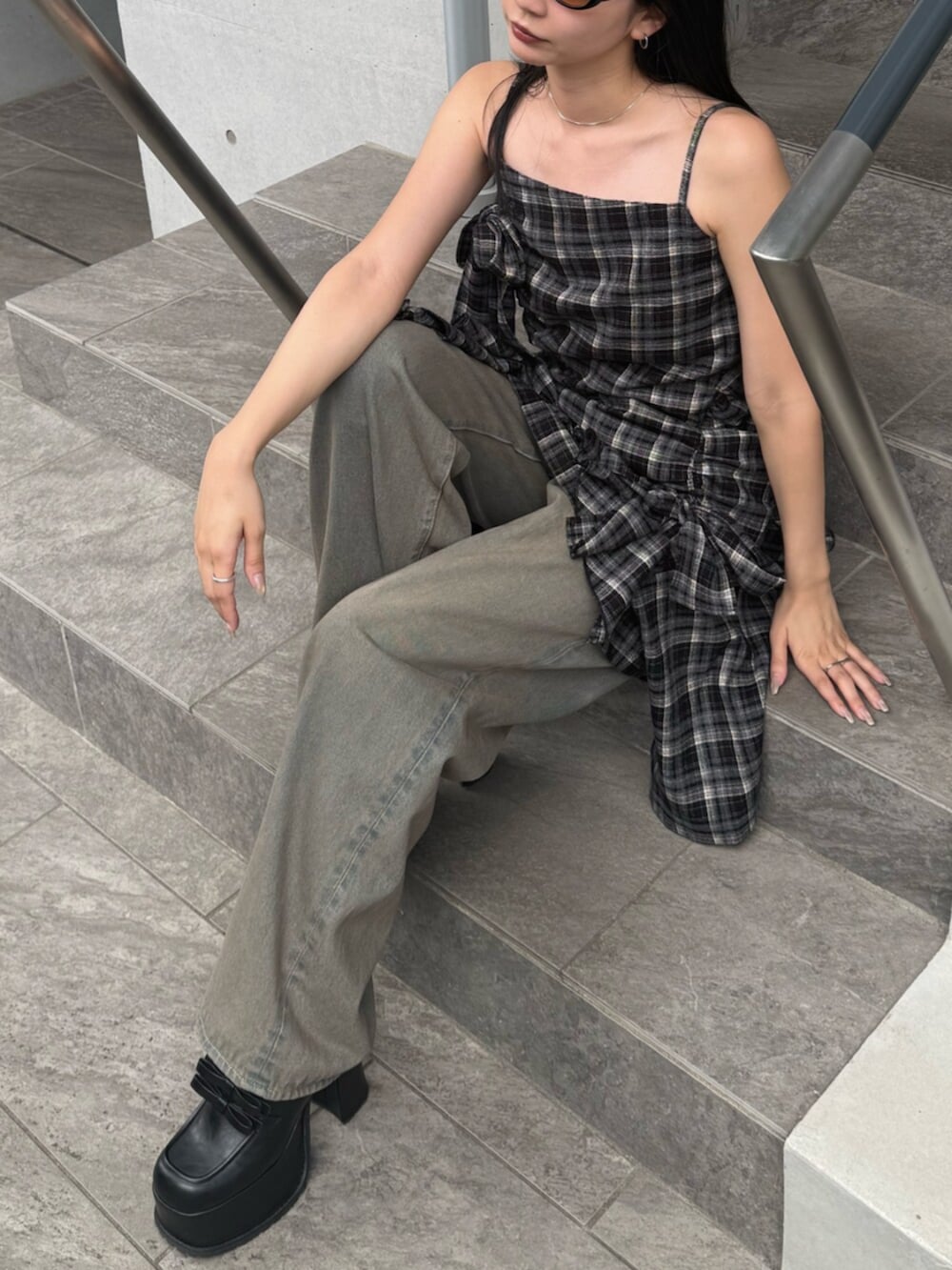 ブラウン系のデニムパンツ、ブラック系のワンピース、ブラック系のローファーを着用したレディースの夏コーディネートの5枚目の写真