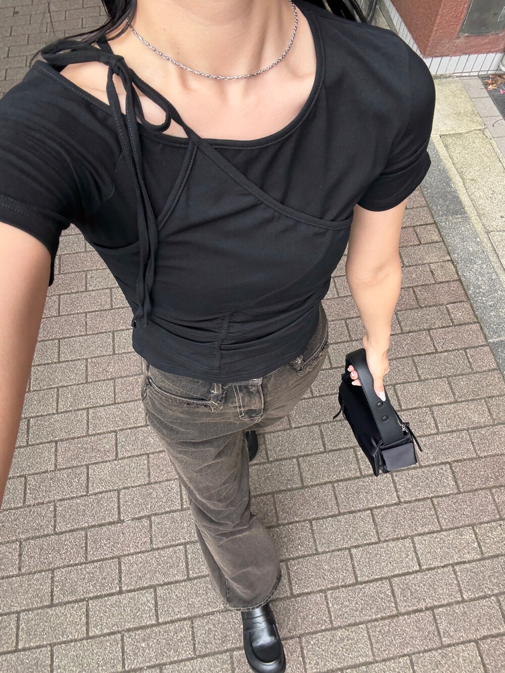 ブラック系のTシャツ/カットソー、ブラック系のデニムパンツを着用したレディースの夏コーディネートの2枚目の写真