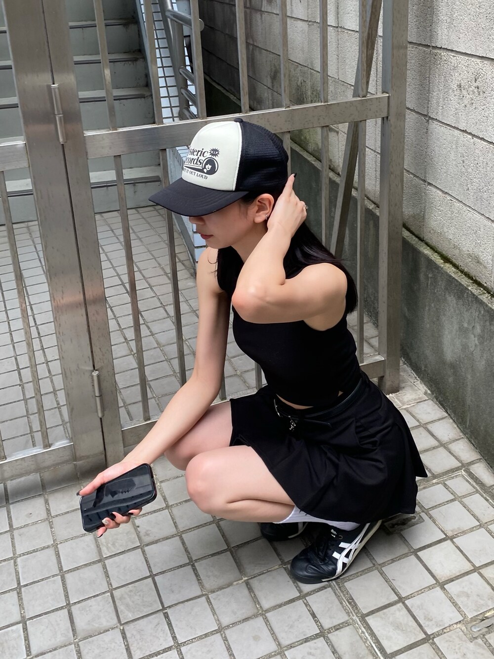 ブラック系のスカート、ブラック系のタンクトップを着用したレディースの夏コーディネートの2枚目の写真