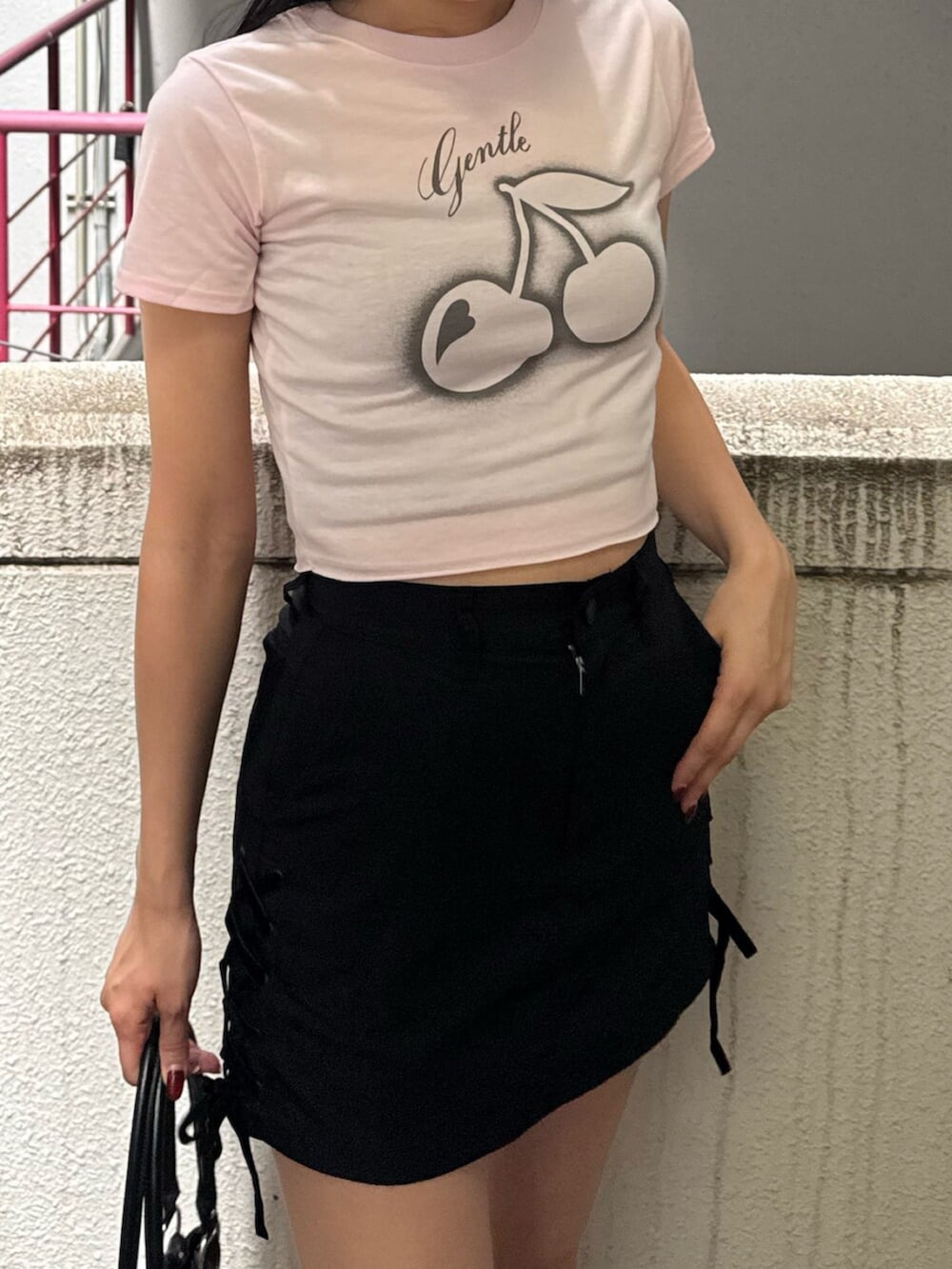 ブラック系のサンダル、ブラック系のショルダーバッグ、ピンク系のTシャツ/カットソーを着用したレディースの夏コーディネートの6枚目の写真