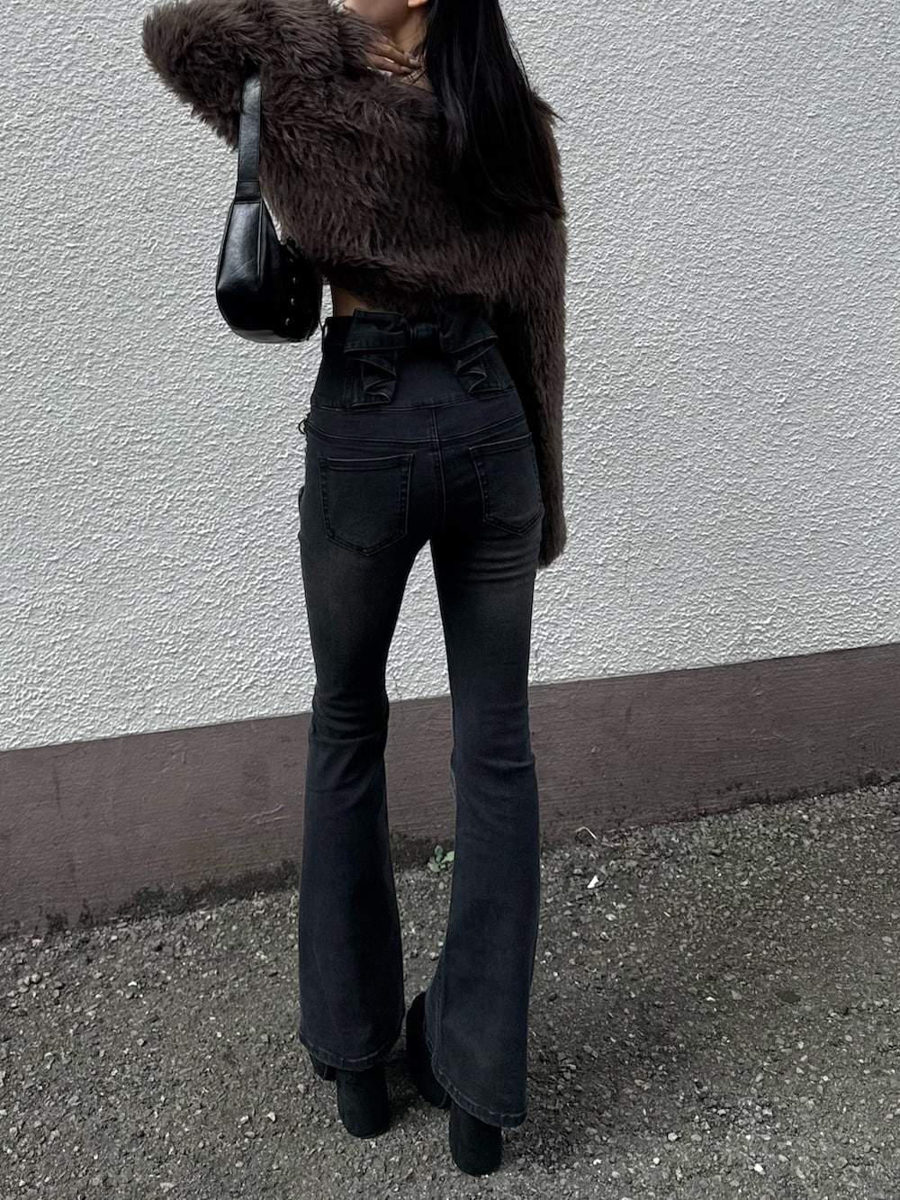 ブラック系のデニムパンツ、ブラウン系のニット/セーターを着用したレディースの冬コーディネートの2枚目の写真