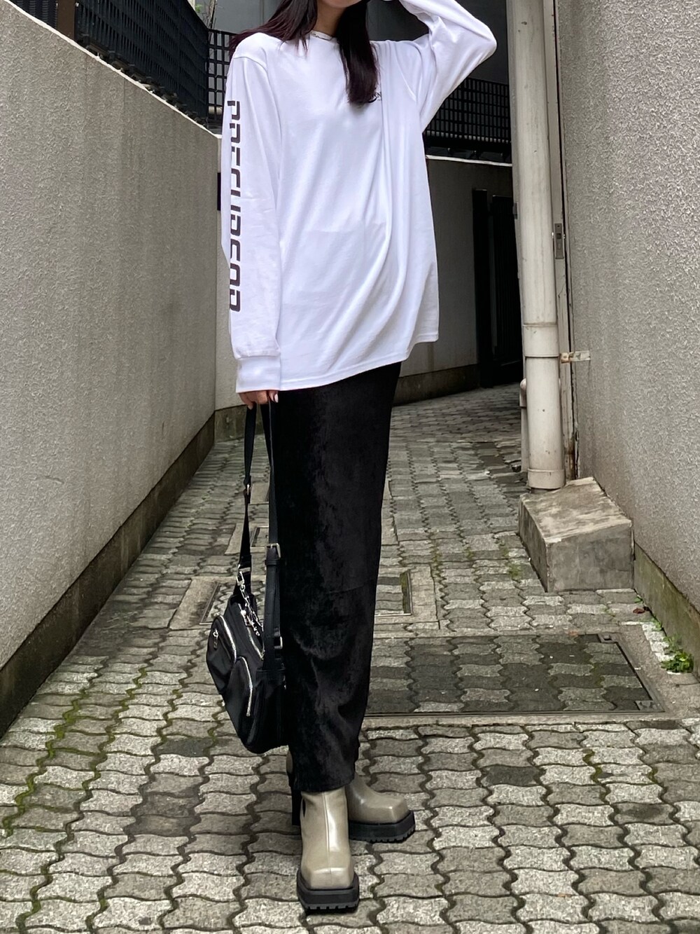 ホワイト系のTシャツ/カットソー、ブラック系のスカート、グレー系のブーツを着用したレディースの秋コーディネートの4枚目の写真