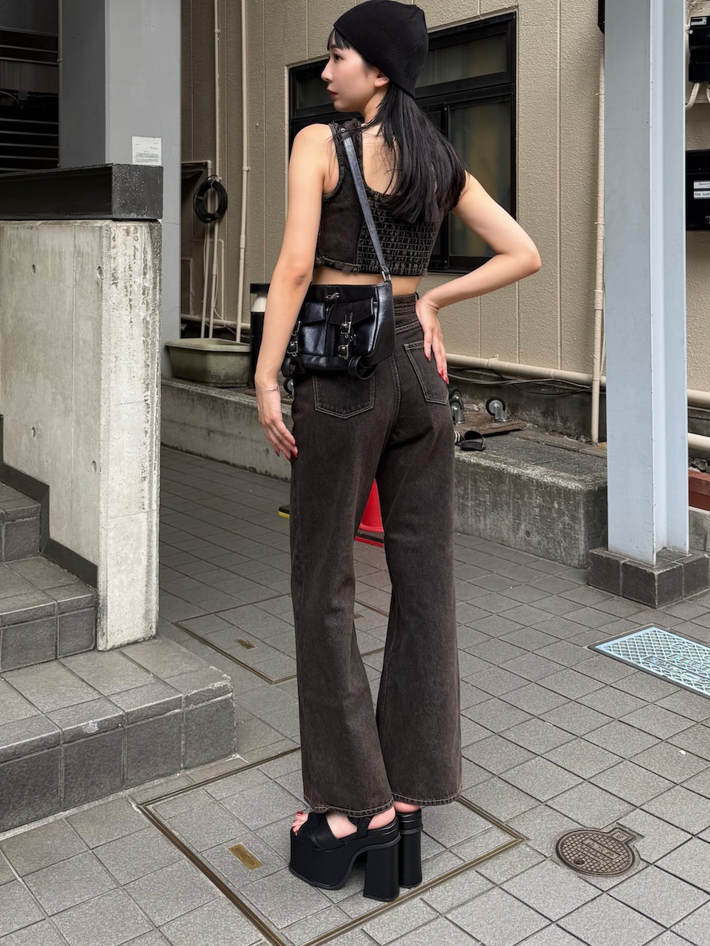 ブラック系のデニムパンツ、ブラック系のタンクトップ、ブラック系のサンダルを着用したレディースの夏コーディネートの2枚目の写真